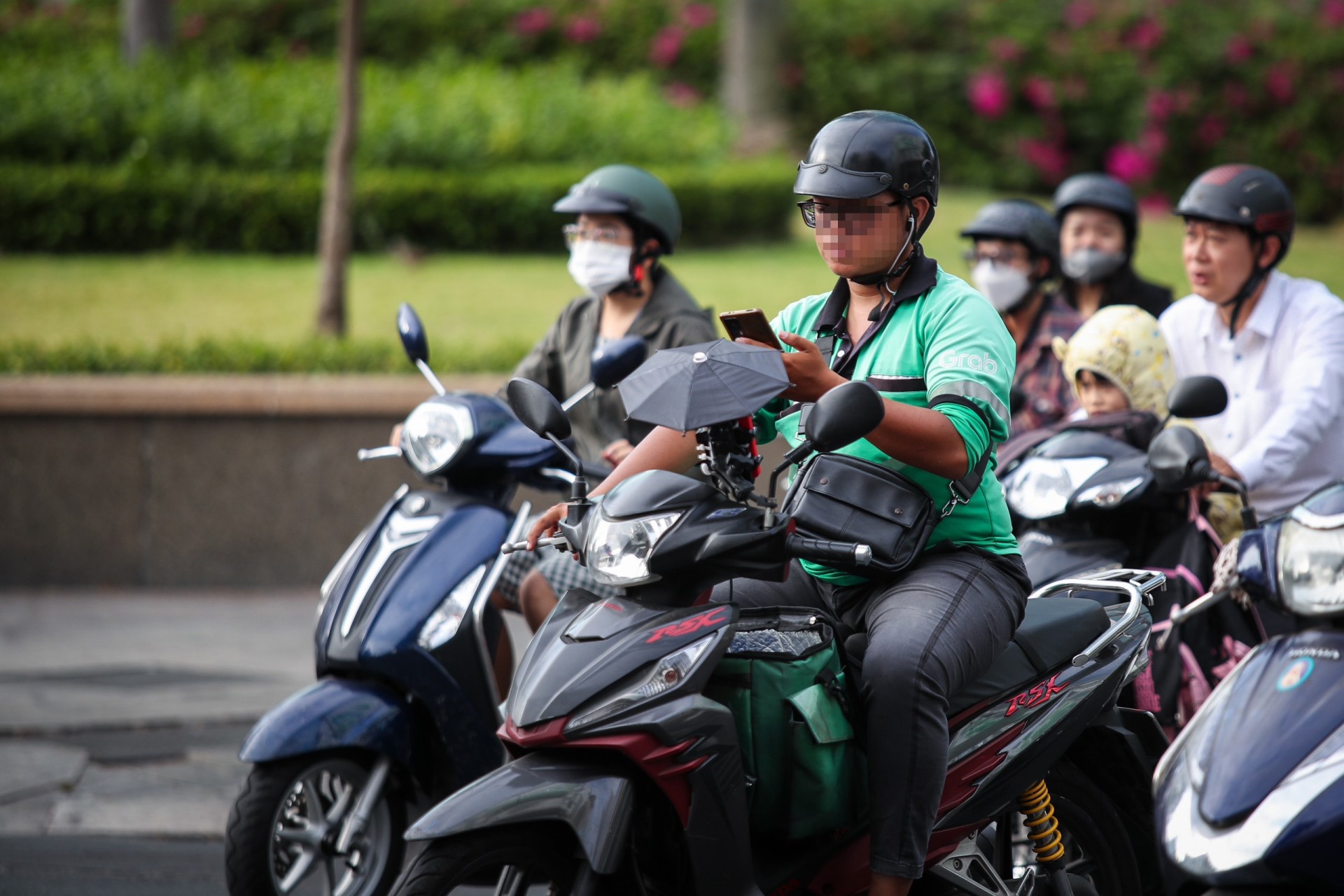 Đeo tai nghe, che ô khi đi xe máy bị phạt bao nhiêu tiền?