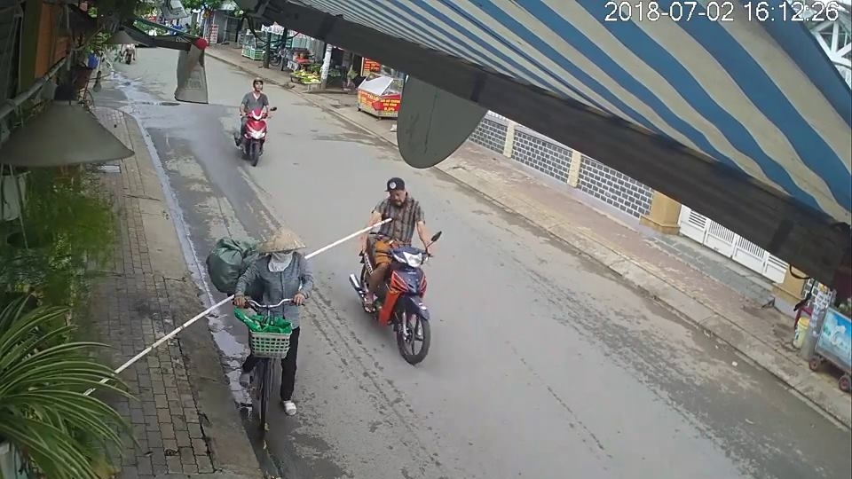 Cây gậy dài chọc ngã nhào người đi xe máy