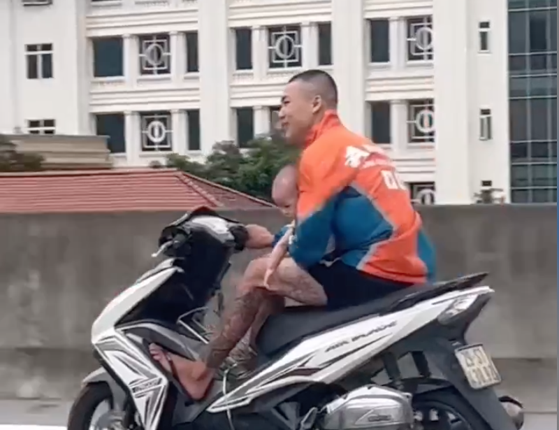 Lái xe máy một tay bế trẻ em chạy trên đường cấm