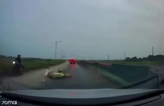 Hú hồn khoảnh khắc người đi xe máy lấn làn, đi vào giữa khe hai xe lớn và ngã ra đường, suýt bị bánh xe cán qua người