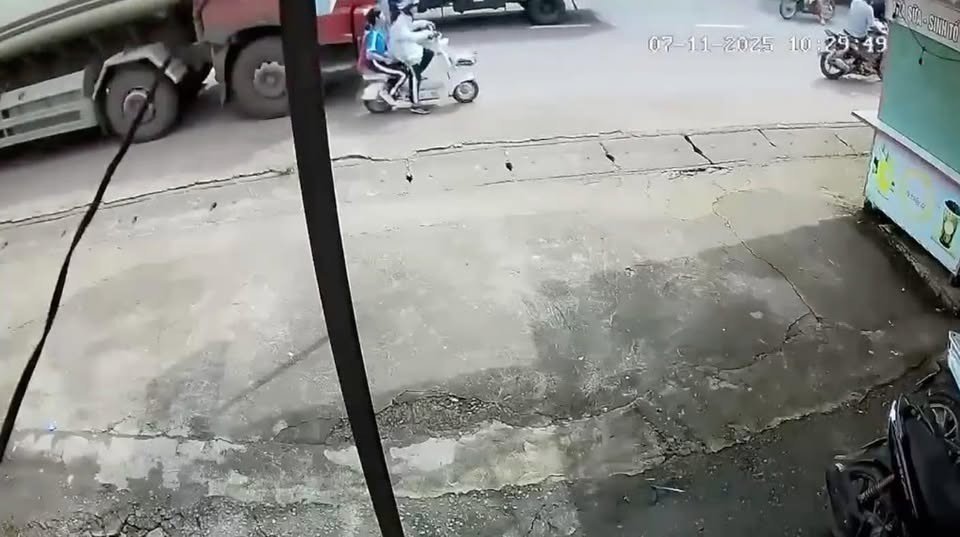 Xe điện bị xe máy đi ngược chiều va phải, hai em học sinh ngã ra đường, bị container chèn qua người