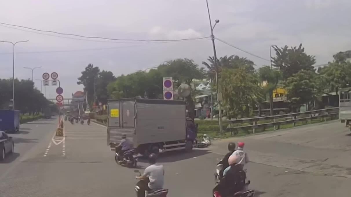 Cố vượt khi xe tải đang rẽ, cô gái lái xe máy bị hất văng lên dải phân cách có trồng cây xanh
