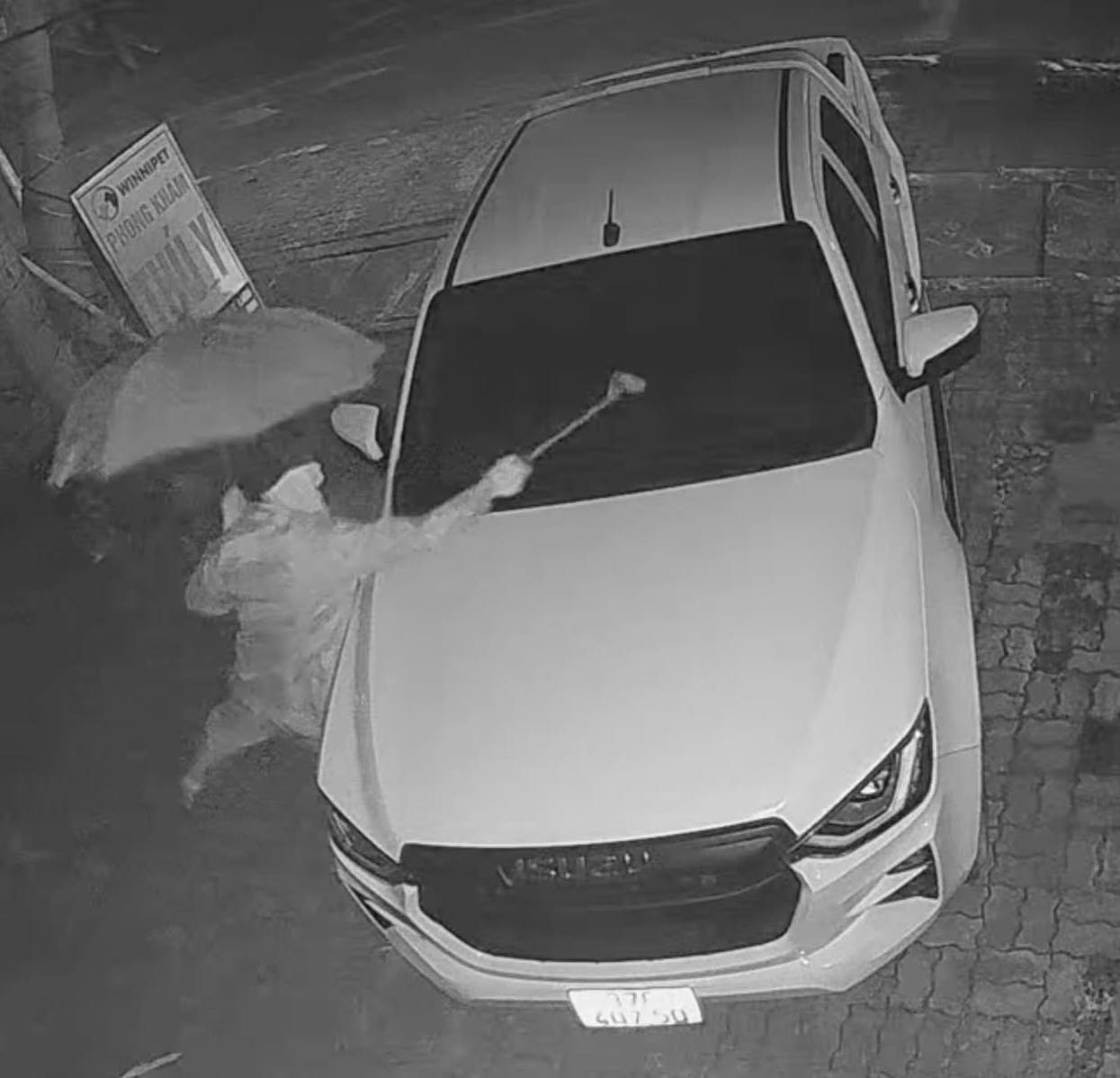 Người đàn ông mặc áo mưa, che ô đập phá xe nhà hàng xóm