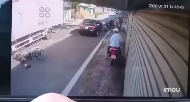 Va vào đuôi xe ô tô rồi ngã ra đường, thanh niên đi xe máy va chạm với xe tải