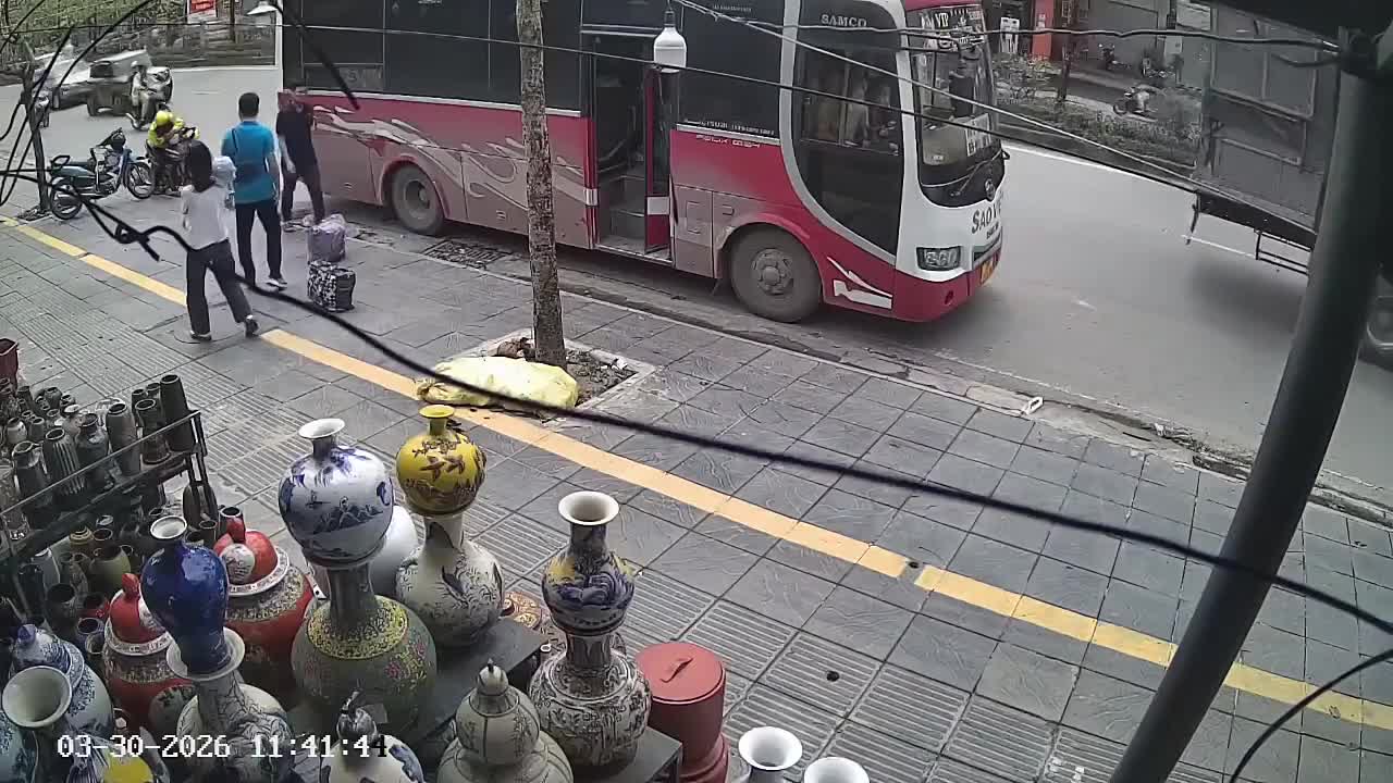 Xe khách đang chạy nhanh thì đột ngột tấp vào lề rồi chèn vào xe máy đi ngay cạnh